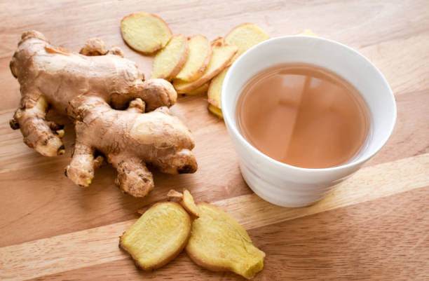 tazza da tè allo zenzero calda con radici di zenzero su sfondo legno. - drink brown herb heat foto e immagini stock