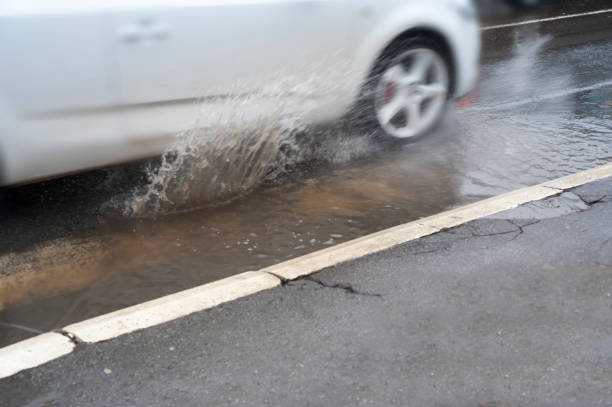 istock car driving through a flooded road 914157776