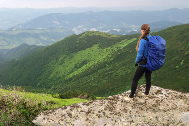 istock Woman with backpack standing on mountain 914158680