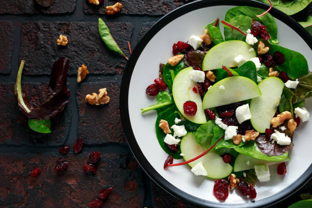 домашний осенний яблочный клюквенный салат с грецким орехом, сыром фета и овощами - cranberry salad стоковые фото и изображения