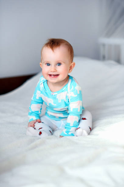 istock Cute smiling baby sitting on a white blanket 914170036