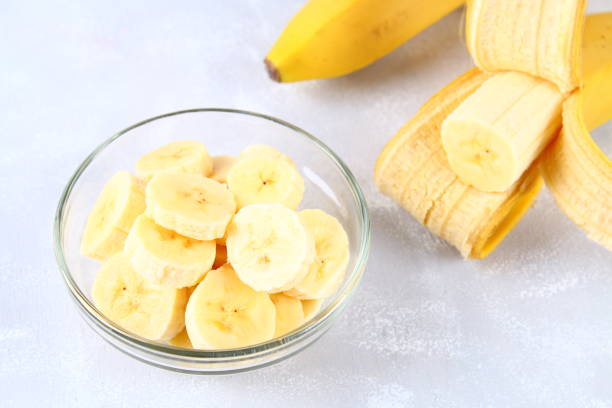 istock Bananas are whole and cut on a slice in a cup on a gray background. 914173030