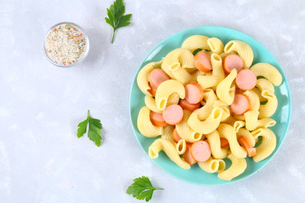 istock Pasta Cavatappi or Cellentani with sausages on a gray table. 914173308