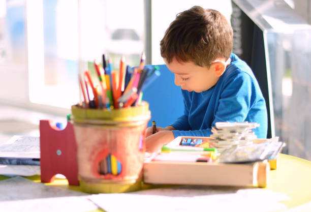 istock Creative child coloring on paper in playroom 914186610