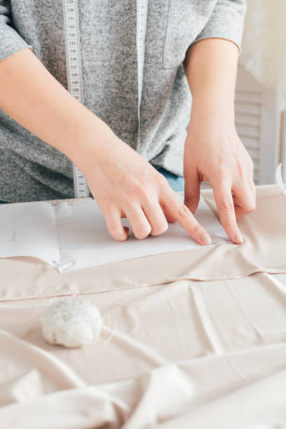 istock Young seamstress makes clothes cutting fabric 914187318