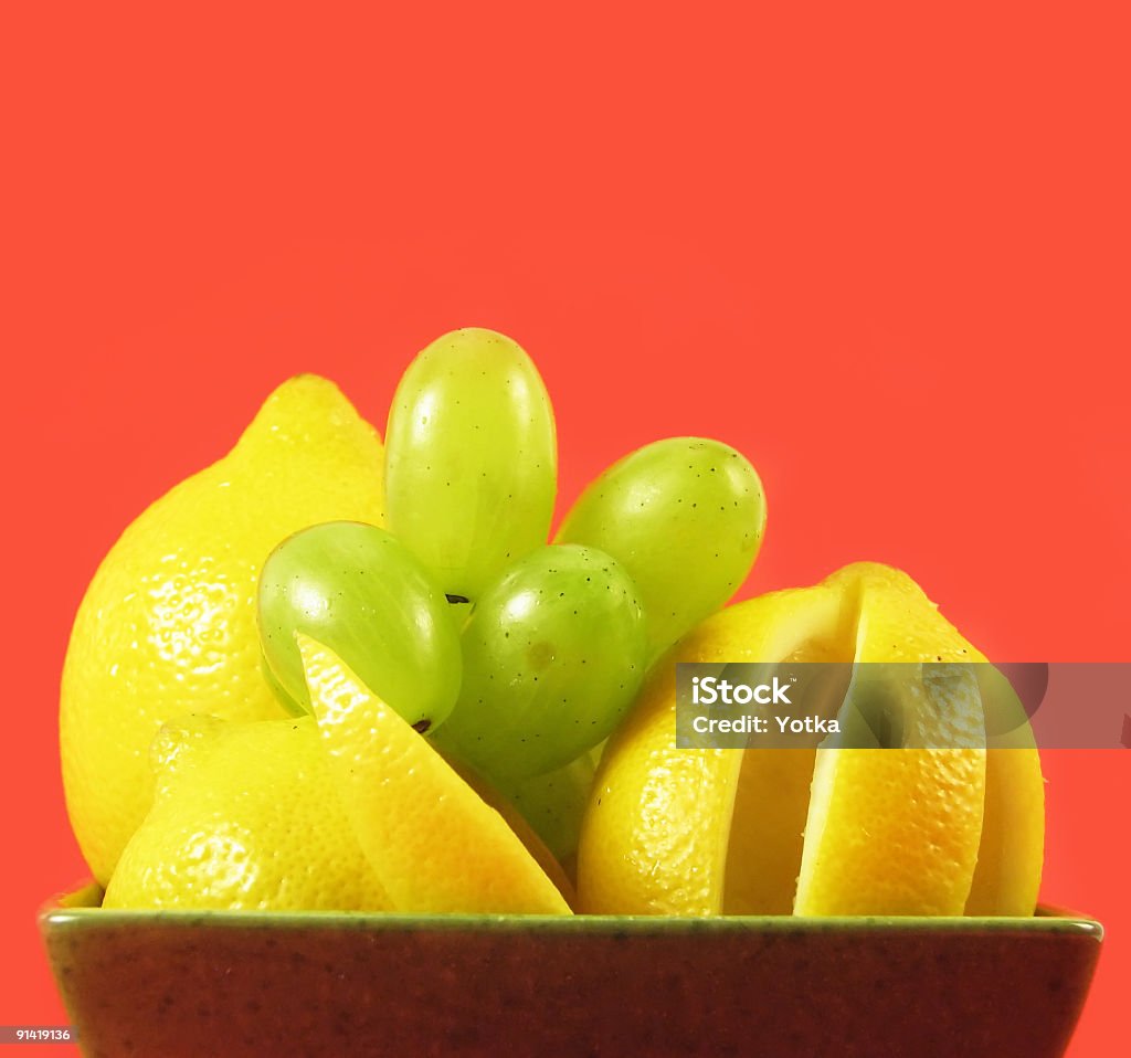 lemons and grapes fruits lemons and grapes in green bowl on red background Arrangement Stock Photo