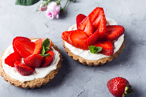 Strawberry tarts with  custard, delicious holiday fruit dessert over light gray background