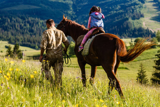 istock Dad teaches his daughter to ride a horse. Lesson with Riding Instructor. 914204184