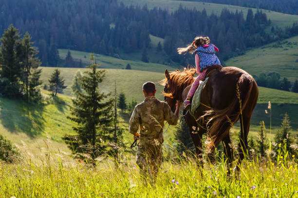 teaches girl to ride a horse. lesson with riding instructor. - teaching child horseback riding horse imagens e fotografias de stock