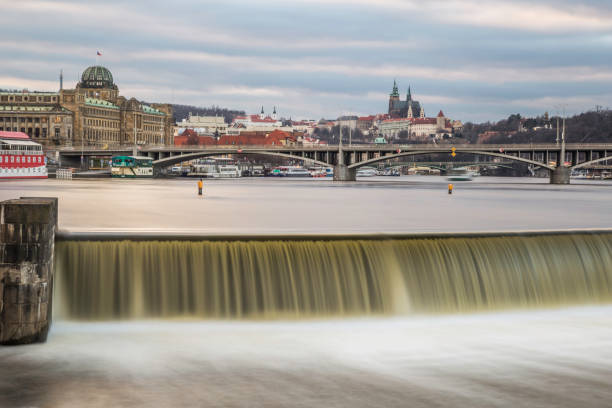 Unusual evening view of the city and the Prague Castle with a weir on the river Vltava and bridges in the foreground. Sunset and colorful clouds over the city. dancing house prague stock pictures, royalty-free photos & images