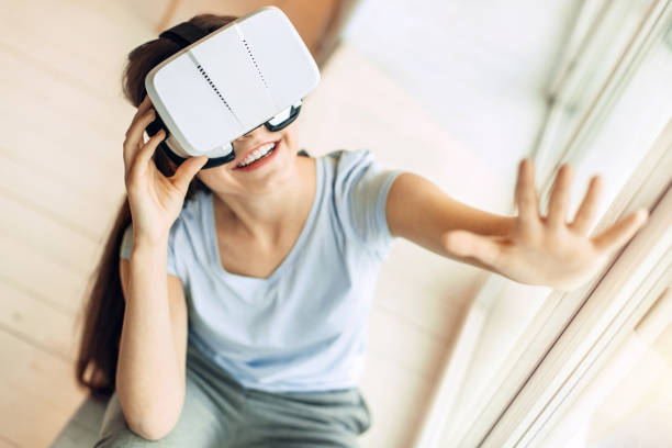 istock Top view of cheerful girl playing with VR headset 914246268