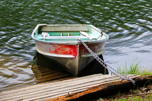 istock An aluminum row boat chained to the shore by a dock 914280356