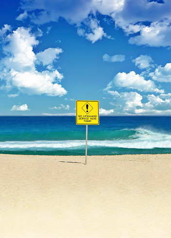 a sign with a crossed out silhouette of a swimming man and the inscription in Russian -swimming is prohibited- on the shore of the Baltic Sea