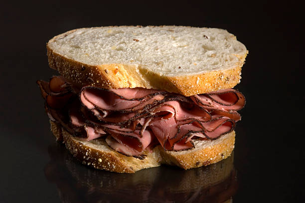 Pastrami sandwich and pickles on a table