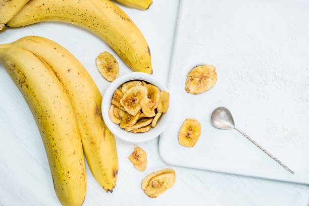 istock Fresh made Dried Banana Chips isolated on white background close up 914295004