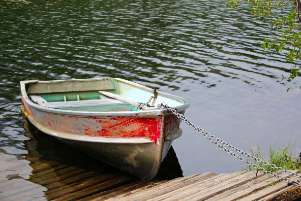 istock An aluminum row boat chained to the shore by a dock 914314198