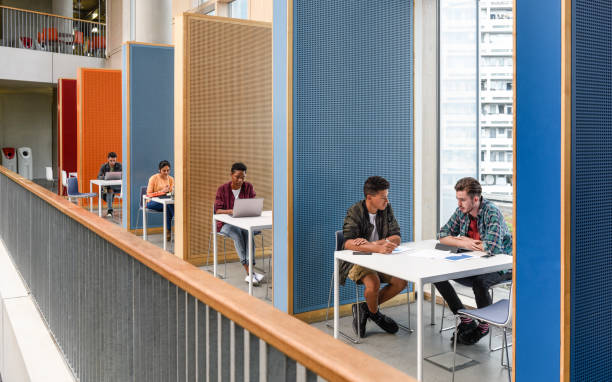 Students working in modern study cubicles at FE college Row of colourful booths for student study, separated by partitions, providing privacy and space to work and meet office cubicle photos stock pictures, royalty-free photos & images
