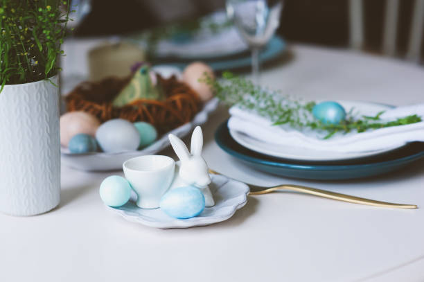 istock easter and spring festive table in nordic scandinavian style, decorated in blue and white natural tones with eggs, bunny, fresh flowers and candles. 914314530