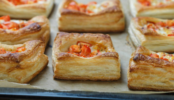Puff pastry with tomatoes and mozzarella on a baking sheet. The homemade pies. Selective focus