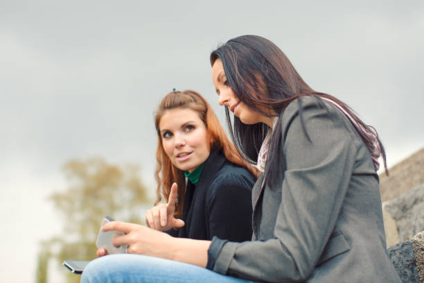 istock Young friends sitting at riverbank 914319814
