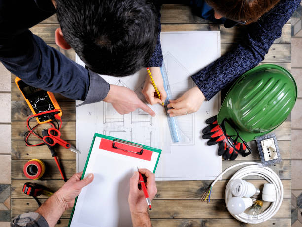 istock Young architects and technicians analyze the project of a residential house 914327260