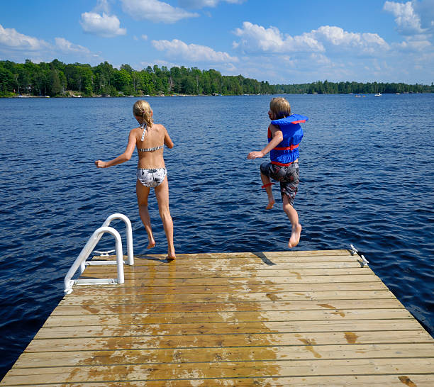 lago salta! - life jacket little boys lake jumping foto e immagini stock