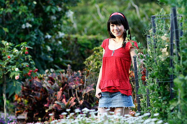 istock girl in red top standing inside a garden 91434059