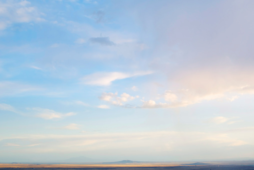 Aerial view of bright yellow sunset over pink purple dense clouds with blue sky overhead, top view from an airplane. Sky Gradient. Can be used as advertising background, overlay. Travel concept.