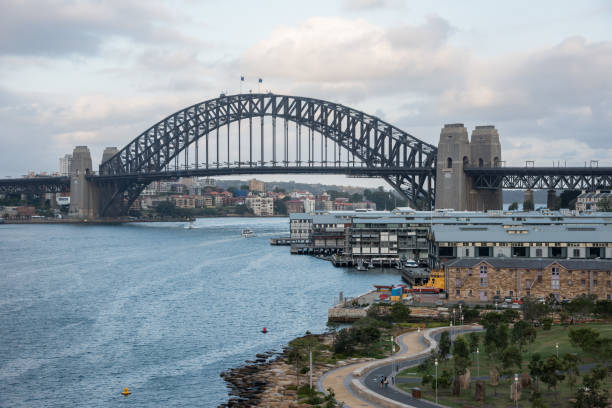 Sydney, NSW, Australia-December 7,2016: Sydney Harbour Bridge with luxury riverside apartments and garden path in Sydney, Australia