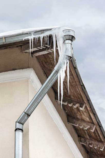 alte hausdach mit gefährlichen großen eiszapfen hängen nach unten entlang fallrohr - icicle hanging snow moving down stock-fotos und bilder