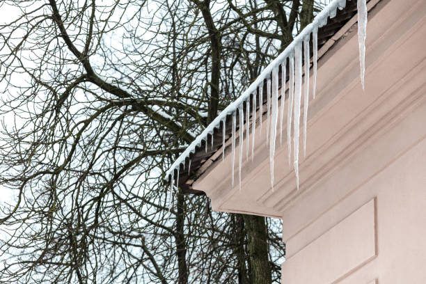 eiszapfen hängen von der haus-traufe - icicle hanging snow moving down stock-fotos und bilder