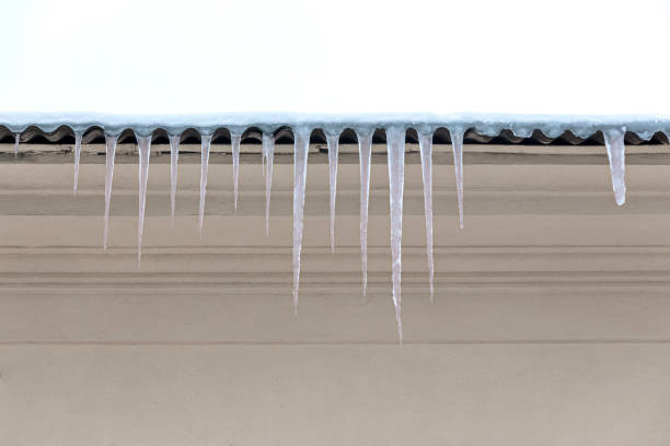 dach mit schnee bedeckt, eiszapfen hängen nach unten - icicle hanging snow moving down stock-fotos und bilder