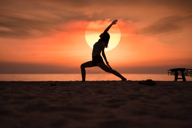 istock Practice Yoga in the sunset beach 914376250
