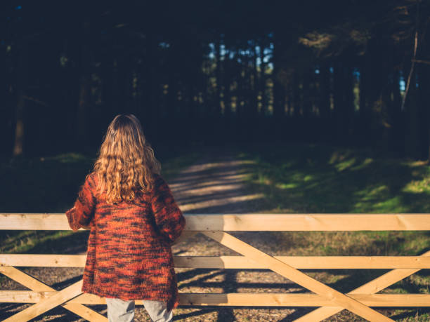 istock Woman by gate in forest 914382344