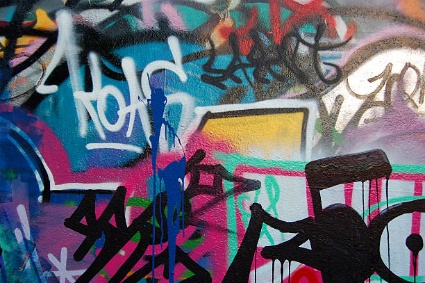 Wall covered in different color graffiti and writing on it A wall covered with graffiti and tags. colouring stock pictures, royalty-free photos & images