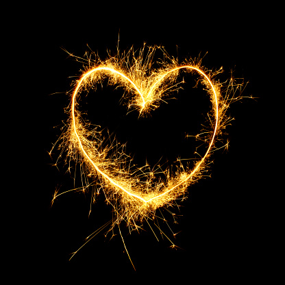Beautiful Sparkling golden heart isolated on black background. Glowing Outline of a heart shape to overlay on the textures in the design Holiday greeting card, background for Valentine's Day, Wedding