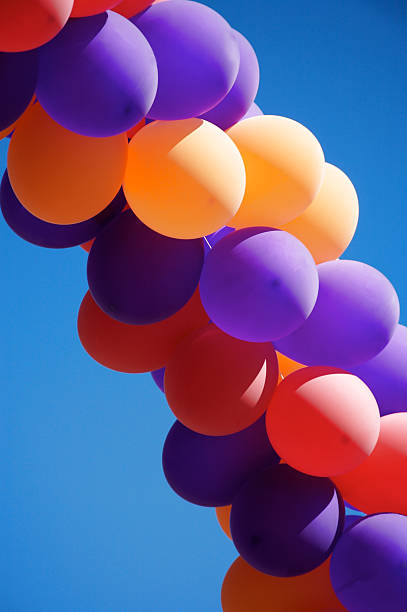 Colorful balloons on bright blue sky with copy space stock photo