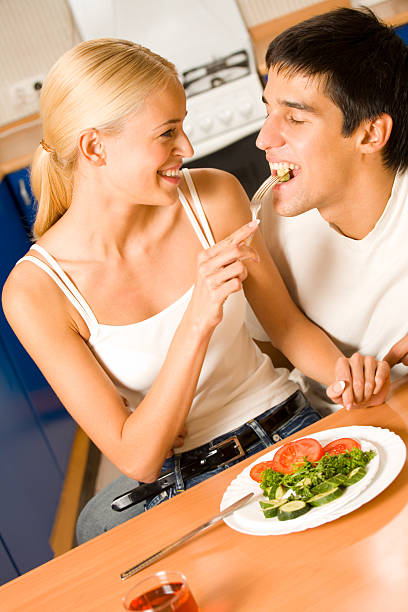 Lustige Szene des jungen Glückliches Paar spielerisch Essen im kitchen – Foto