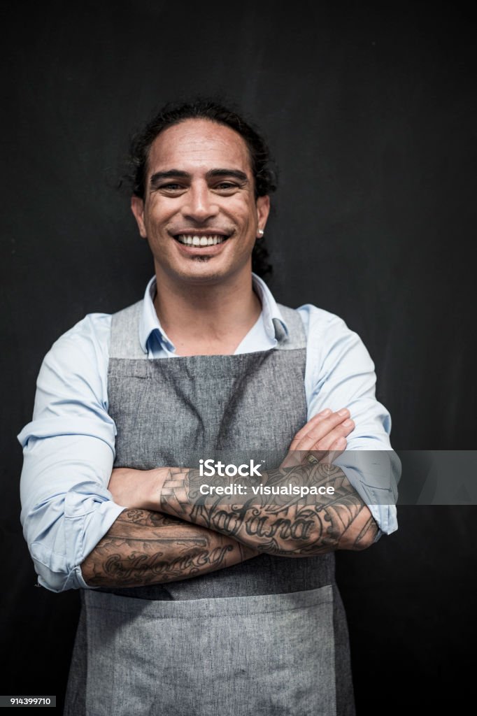 Small Business Owner Portrait of a happy man wearing an apron. Looking at camera, smiling confidently. Māori People Stock Photo