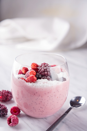 Smothie with red berries (raspberry, strawberry, blueberry, blackberry) in a glass. Frozen red fruits. Healthy breakfast