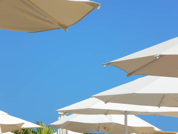 istock White umbrellas and blue sky in summer season 914428158