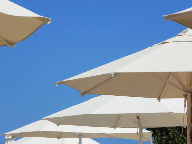 istock White umbrellas and blue sky in summer season 914428162