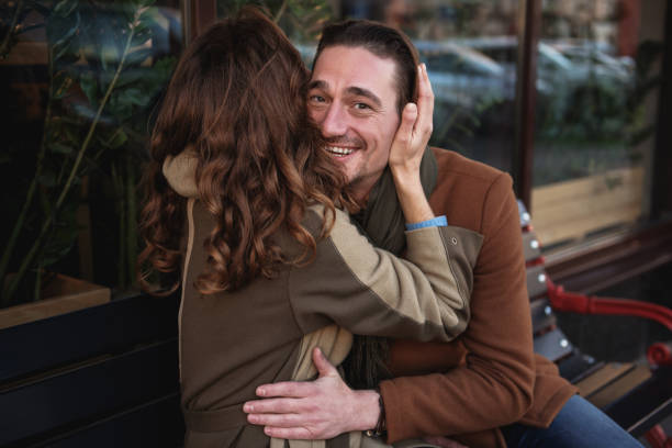 istock Happy loving couple sitting on bench and hugging 914431936