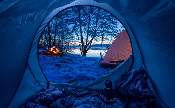 istock Camp by the lake with campfire at dusk in winter 914432254