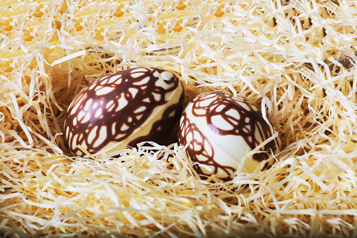Homemake Easter eggs lying on straw in a basket