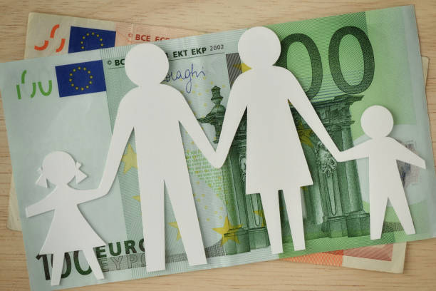 Paper family cut-out on euro banknotes - Family budget concept stock photo