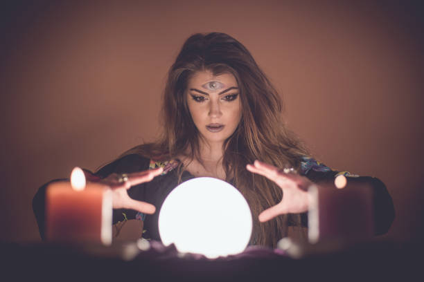 Girl with crystal magic ball Young attractive girl with magic crystal ball prophesies fate fortune teller photos stock pictures, royalty-free photos & images