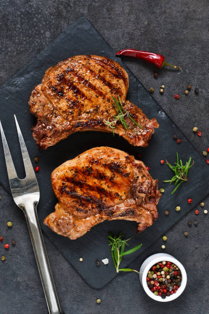 istock Grilled beef steak with spices and tomato sauce on a stone board. 914444144