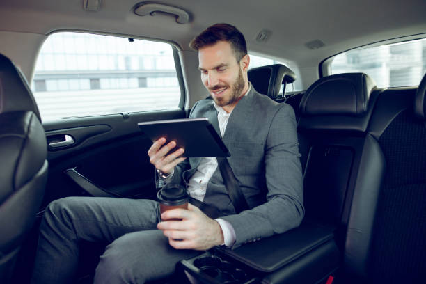 istock Businessman in a car using digital tablet 914466350