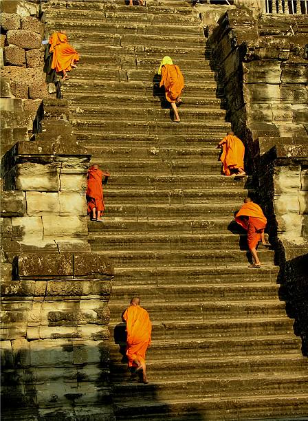 Monks walking upstairs in Angkor